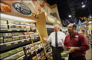 Walt Churchill and assistant manager Kunal Dawar view the K-Cups display at Walt Churchill's Market in Monclova Township. 'K-Cups, they're pretty hot right now,
