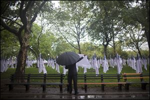 A man reads the names of victims of the Sept. 11, 2001, terrorist attacks, written on U.S. flags as part of  