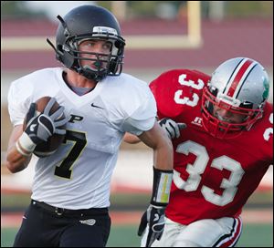 Perrysburg's Austin McKinley (7) runs the ball against Central Catholic's Jimmy Johnston (33) during the first quarter Friday.