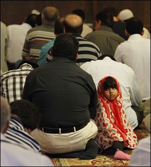 Yasser Ghafoor worships with his daughter, Ruba, 2, by his side at the Islamic Center of Greater Toledo in Perrysburg.