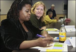 Pairing up to discuss their spending priorities and values are Petronella Holmes, of north Toledo, left, and Candy Huner, of Maumee. The Toledo-Lucas County Public Library presents a seminar 