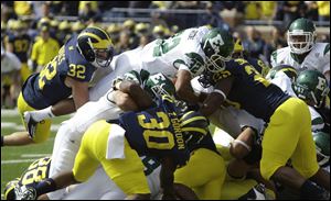 Michigan's Jordan Kovacs (32) and Kenny Demens (25) stop Eastern Michigan's Dominique Sherrer at the goal line.