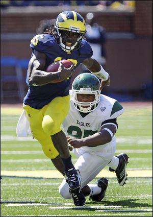 UM’s Denard Robinson gets away from Eastern Michigan’s Kalonji Kashama in the second quarter.

