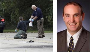 Law enforcement agents, left, put into a bag evidence collected on East Elm Avenue in Monroe in the car bombing that injured Erik Chappell, right, and his two sons.