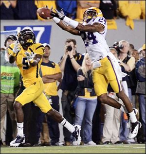 LSU's Tharold Simon, right, breaks up a pass to West Virginia's Ivan McCartney Saturday in Morgantown, W.Va. 