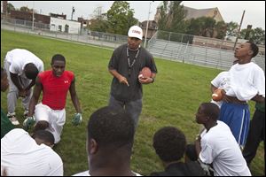 Members of the Frederick Douglas High School football team practices on Tuesday, in Detroit.  The teams  locker room was broken into and more than 20 sets of helmets, pads and cleats were stolen.