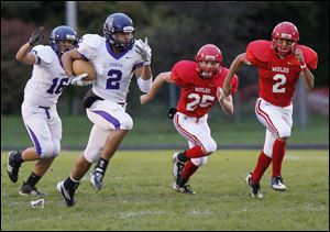 Ann Arbor's Johnson, 2, goes 70 yards followed by Ethan Spencer, 16, on the visitor's first possession to score a touchdown. In pursuit are Bedford's Al Regnier, 25, left and Brendan Renius, 2.