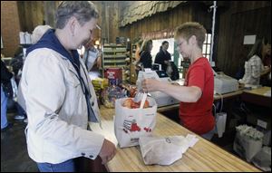 Barbara DeGrande, left, of Farmington Hills, Mich.,  buys apples from  Valerie Mitchell at Erie Orchards and Cider Mill in Erie, Mich.