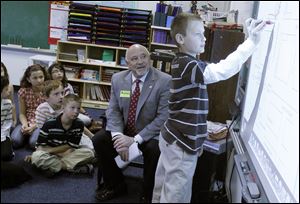 Perrysburg Mayor Nelson Evans listens as Chase Mackiewicz gives him ideas on a right-of-way issue as the mayor visits with fourth graders in Lynn Cherry's class at Woodland Elementary.