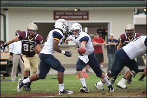 Calebb Goings, a Toledo Central Catholic High graduate, takes a handoff for Siena Heights during a recent game. The Adrian school's inaugural 138-member team has 14 players from northwest Ohio and southeast Michigan.