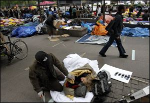 A woman talks to a friend Tuesday after sleeping in Zuccotti Park in the financial district in New York as part of a Wall Street protest.