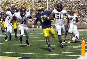 University of Michigan player Vincent Smith, 2, outruns University of Minnesota players Chase HAviland, 36, Gary Tinsley, 51, and the rest of the defense for a second quarter touchdown at Michigan Stadium, Saturday, October 1, 2011.
