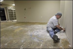 The Rev. Steve Anthony, executive director of Toledo Area Ministries, dons his painting clothes instead of a suit and tie as he helps spruce up the agency's new Monroe Street headquarters.