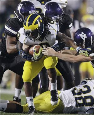 Michigan wide receiver Martavious Odoms tries to squeeze past Northwestern defenders.