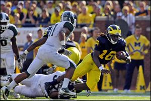 Michigan quarterback Denard Robinson (16) is tripped up on a carry in the second quarter of last year's game. The Wolverines lost 34-17.