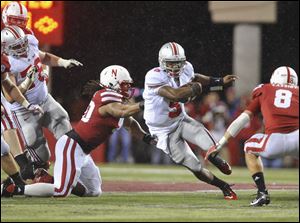 Ohio State quarterback Braxton Miller (5) runs past Nebraska's Terrence Moore, left, and Austin Cassidy (8) in the first half Saturday's game.