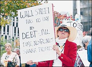 Sandra Frank of Toledo holds a sign demanding
Wall Street repay its debts. The Occupy Toledo event, the local version of theanti-Wall Street
movement that has sparked imitators nationwide, attracted about 100 people.