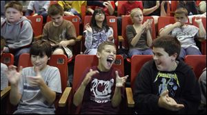 Left to right fifth graders Deven Miller, Drew Bertz, and Zack Prater, cheer Rossford School District teacher Karen Gunn.