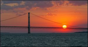 The sun sets over the Mackinac Bridge and the Mackinac Straits as seen from Lake Huron.