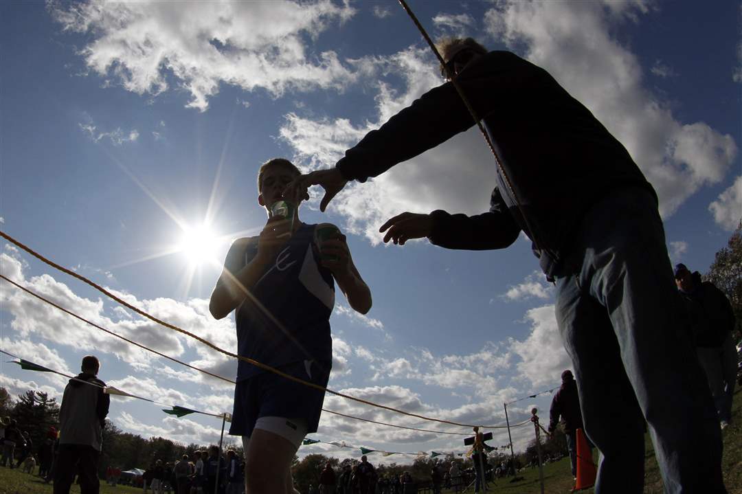 A-runner-gets-a-sip-of-water-after-finishing-the-NLL-cross-country-meet