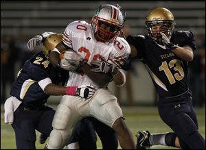 St. John's defenders, including Jamahl Jones, Jake Wheeler (not seen) and Cam Brickman take down Central running back Amir Edwards.