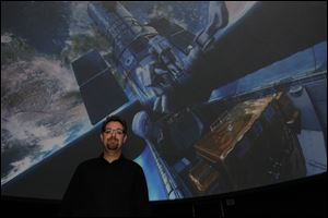 Ritter Planetarium Director Michael Cushing shows the Spitz SciDome video system that can project movies hemispherically on the domed ceiling of the facility on the University of Toledo campus.