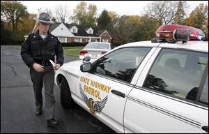 Sgt. Brian Foltz, with the Ohio Highway Patrol, returns to his vehicle after citing a driver for violating school bus traffic laws near the Sylvania Whiteford Elementary School on October 18.