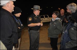 Muskingum County Sheriff Matt Lutz speaks to individuals from The Wilds, a wildlife conservation center in Cumberland, Ohio, and The Columbus Zoo and Aquarium about exotic animals loose in the area. 