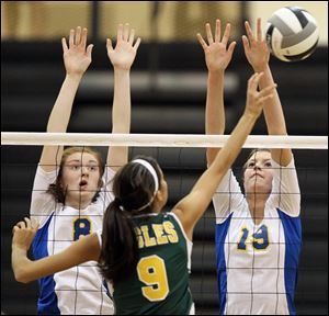 St. Ursula's Lauran Graves, 8, and Maddie Burnham, 19, defend against Clay's Taylor Kovach, 9, Tuesday, during the Division I volleyball district semifinals in Perrysburg.