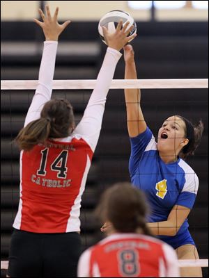 St. Ursula's Erin Williams, right, spikes the ball against Central Catholic's Olivia Pina yesterday.