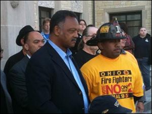The Rev. Jesse Jackson, left, addresses an anti-Issue 2 crowd Wednesday on the University of Toledo campus.