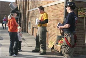 From left to right,  Shannon kellough and Levi kellough, 3, talk to Toledo firefighters Jason Johns and Dave Mather outside the Our Lady of Perpetual Help School polling place in South Toledo. Toledo firefighters Firefighters campaign for the defeat of ballot Issue 2 at Our Lady of Perpetual Help School at 2255 Central Grove in South Toledo.