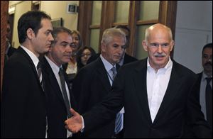 Greek Prime Minister George Papandreou, right, arrives for a cabinet meeting Tuesday at the parliament in Athen.