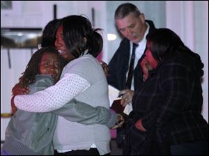 Bystanders react as authorities respond to a homicide at 339 Weber St. in Toledo, where, police say, two men opened fire inside.