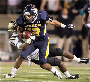 University of Toledo WR Eric Page runs the ball against  Western Michigan's Donald Celiscar (34) during the second quarter Tuesday.