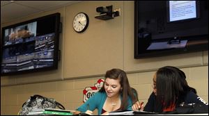 Seniors Michaela Isbell, left, and Jalyn Jones, right, participate in a lesson during an AP English distance learning class which is transmitted from Start High School with one teacher to all six high schools. The program is part of the TPS transformation plan that broadens the district's upper level course offerings in a low cost format.