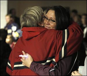 Family friend Luann Kralovic, left, gives Katie Keller, Kerry Keller's sister, a hug after a vigil for the Rossford High School junior who is battling cancer.
