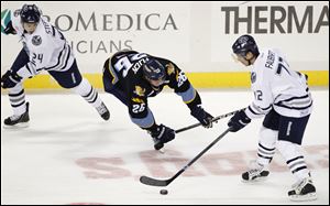 Toledo Walleye center Rob Flick falls to the ice between Chicago Express defenseman Evan Stephen (24) and right winger Pierre-Luc Faubert (72) during the second period.
