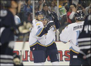 Toledo Walleye players Kyle Rogers (17) left, and Bryan Rufenach (21) right, celebrate a first period goal by Rogers against the Chicago Express in an ECHL opener at Huntington Center, Saturday.