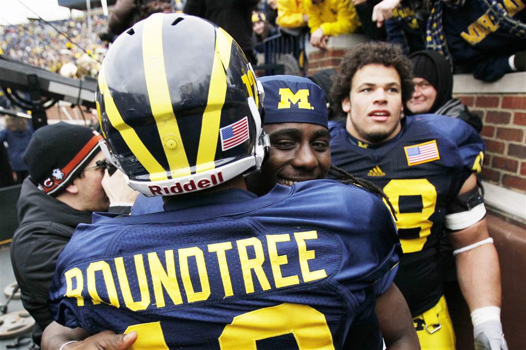 UM-coach-Roy-Roundtree-hugs-Denard-Robinson-after-their-victory-over-Nebraska