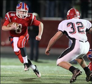 Patrick Henry  quarterback Anderson Okuley (8) runs the ball against Hicksvill's Seth Klepper (32) Friday during a playoff game at Lima Senior High School in Lima.