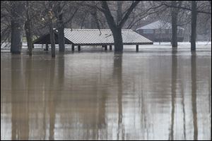 Water nearly reaches the roof of a picnic shelter in Ellis Park along the River Raisin in Blissfield, Mich.  