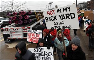 Dozens of protestors line the sidewalks outside of Youngstown's Covelli Centre to show their distrust with hydraulic fracturing to retrieve natural gas. The rally coincided with an industry convention.