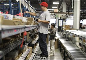 An employee scans inventory at the Nintendo of America Inc. distribution center in North Bend, Wash. A report released Wednesday says private employers added 206,000 jobs last month.