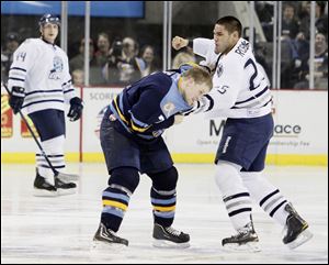 Toledo Walleye player Matt Krug (7) and  Chicago Express player Bobby Robins (25) fight during the second period at the Huntington Center, Saturday.