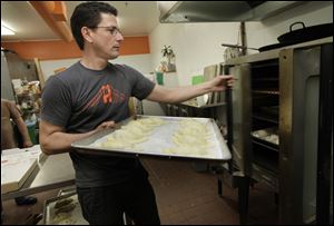Manuel Godino loads an oven with fresh empanadas at the San Francisco restaurant he opened with a $45,000 loan at 7.5 percent interest from Opportunity Fund.