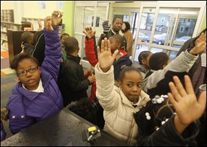 Old West End Academy second-graders in Diane Rausch’s class ask for library card applications after touring the reopened Kent Branch.
