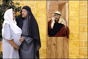 Abby Wozniak as Mary, Mel Oliver as Joseph, and Randy Fall as an innkeeper are dressed for the interactive presentation of 'The Bethlehem Experience' at Westgate Chapel in Sylvania Township.