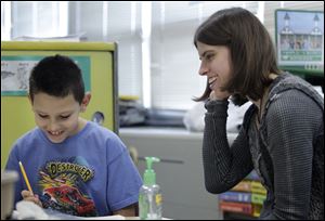 Jenna Karg, 20, of Upper Sandusky, Ohio, helps Mason McLaughlin, 10, at Frank Elementary School in Perrysburg. 