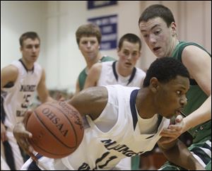 Maumee Valley's Julius Turner tries to dribble past Ottawa Hills defender Geoffrey Beans. Turner had 13 points with 11 of them coming in the first quarter as the Hawks got off to a quick start.